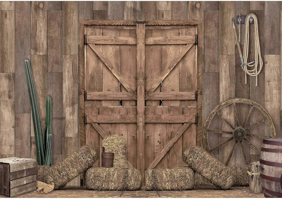 A rustic wooden barn door backdrop featuring weathered wood and hay bales for western photography.
