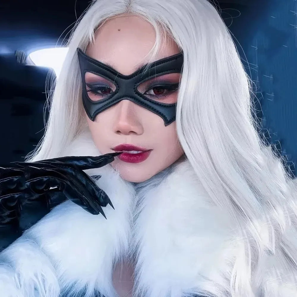 A woman with long white hair and black cat eye masquerade mask wearing a white fur collar.