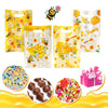 Yellow and white honeycomb patterned gift bags with handles filled with honey and bee designs