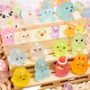 A collection of glowing resin animal figurines in various colors like pink, yellow, green, and blue arranged on a wooden tray