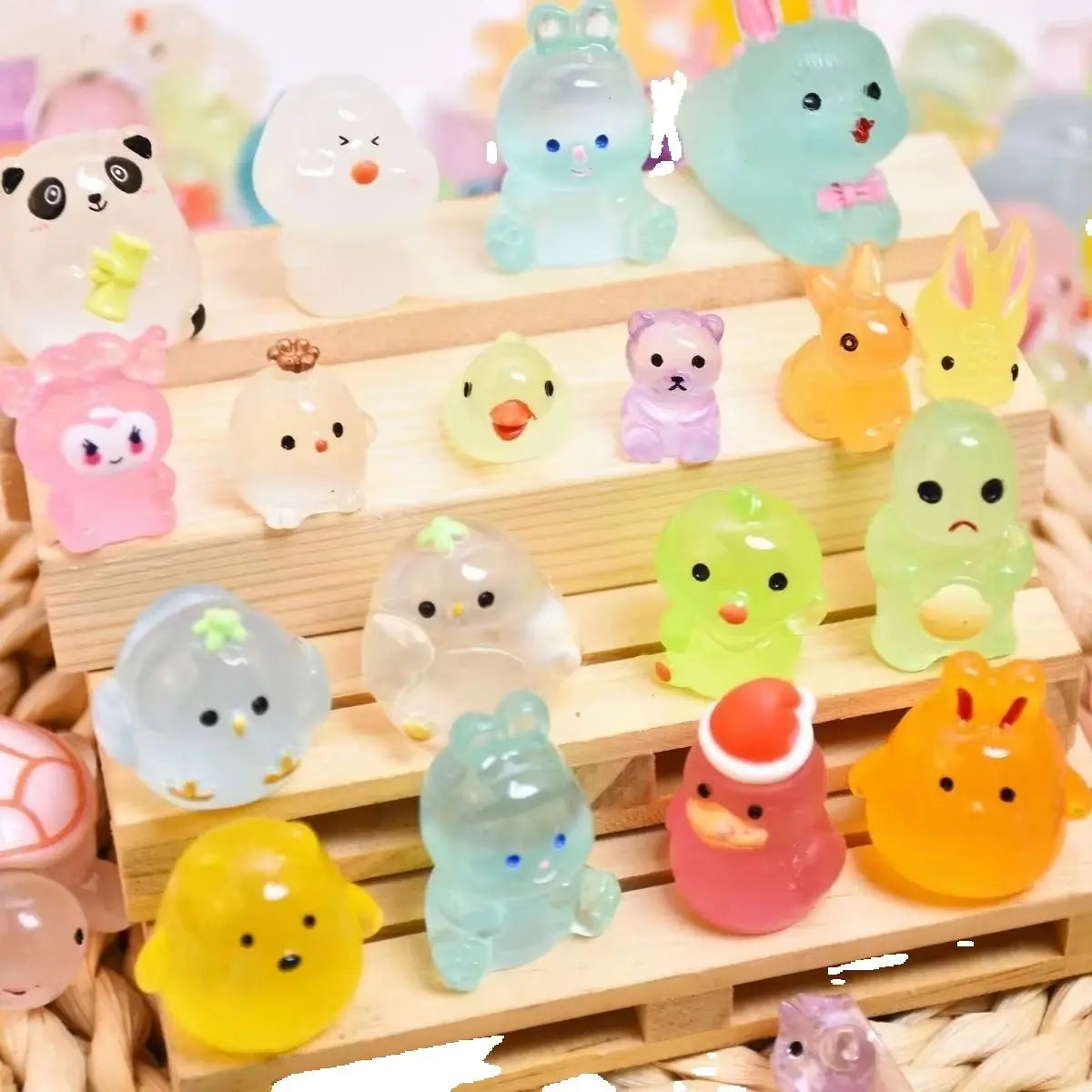 A collection of glowing resin animal figurines in various colors like pink, yellow, green, and blue arranged on a wooden tray