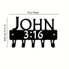 Black metal wall-mounted key holder with seven hooks displaying the name John and time 3:16