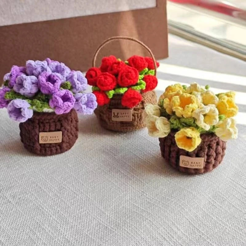 Three hand-crocheted rose flower coasters in purple, red, and yellow displayed on a white surface.