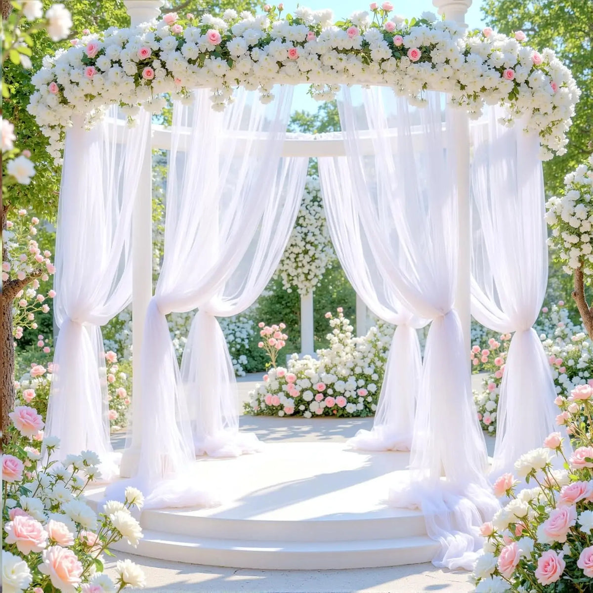 An elegant white tulle floral archway backdrop for events and celebrations surrounded by pink and white flowers.
