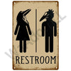 A vintage metal sign depicting silhouettes of a male and female figure for a restroom entrance.