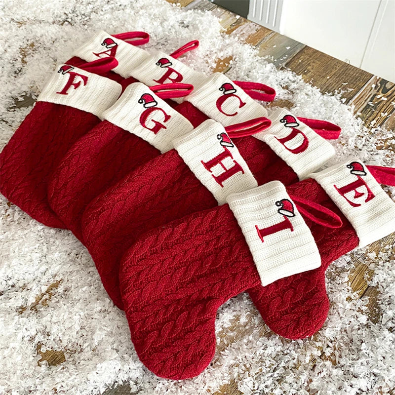 A set of red knitted alphabet socks shaped like letters A through I for Christmas tree decor
