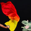 A hand holds a large, vibrant red and yellow silk ribbon dance fan against a black background.