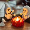 A set of white ghost figures surrounding a glowing orange campfire on a wooden surface.