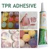 A bottle of clear TPR adhesive for repairing squishy toys, shown next to various colored squishy toys.