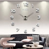 A giant acrylic wall clock displaying the time, set above a modern sofa and table.