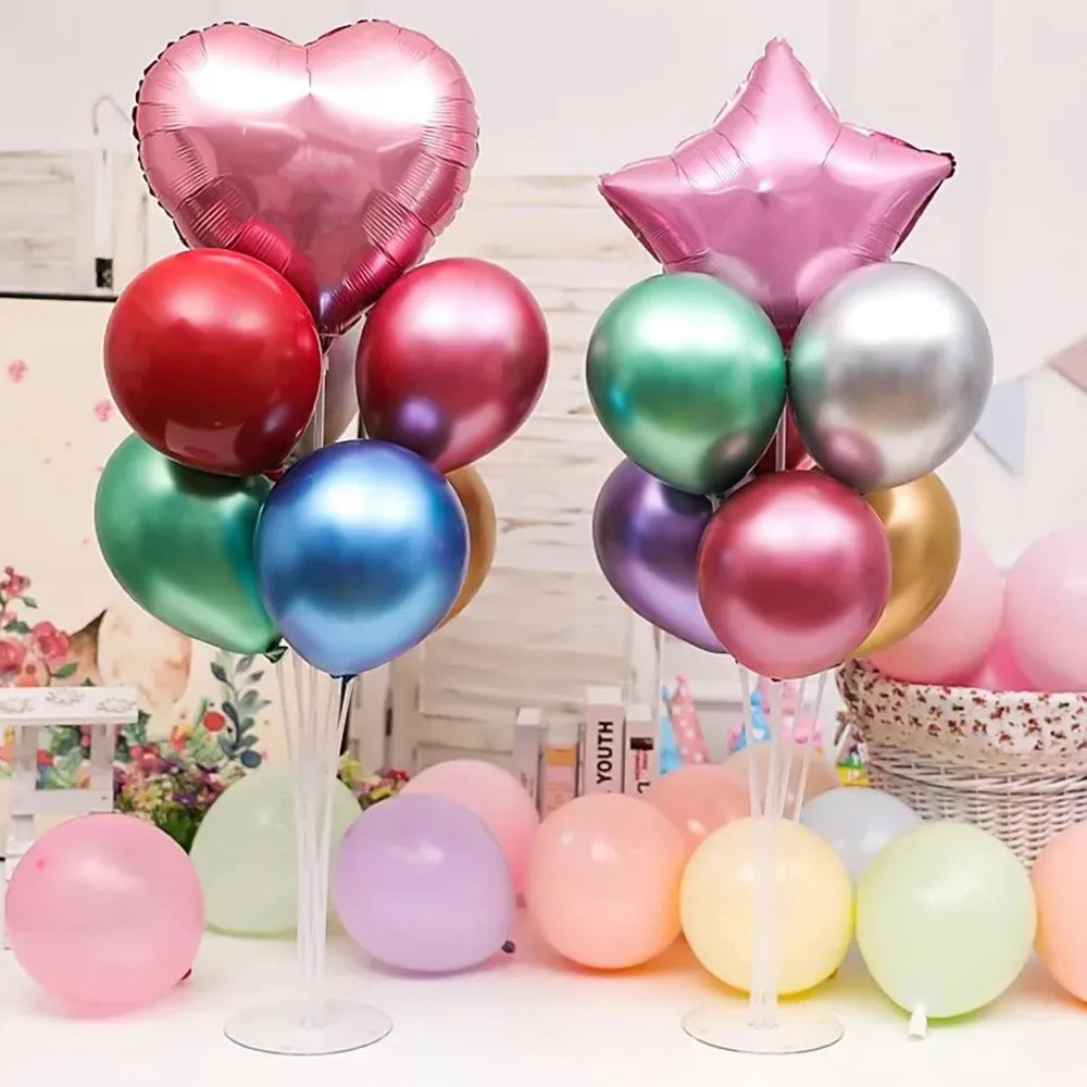 Collection de ballons roses, argentés et verts présentés dans des supports transparents pour fêtes.