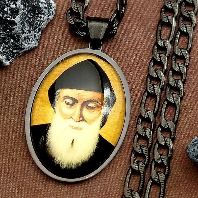 A stainless steel pendant necklace featuring a glass medal depicting Saint Charbel with a beard and cap.