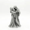 A dark romantic sculpture depicting a couple in hooded figures embracing.