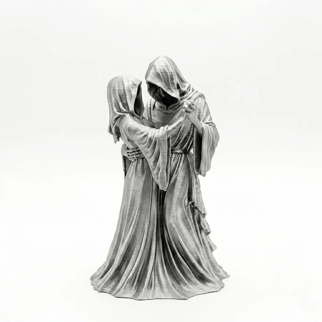 A dark romantic sculpture depicting a couple in hooded figures embracing.