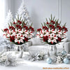 A bouquet of festive red and white artificial flowers displayed on a white table with silver accents.