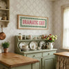 A vintage-style canvas print featuring the text Dramatic Exit in pink and green on a light patterned wall.