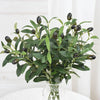 Artificial olive leaf branch with dark green leaves and small berries displayed in a clear glass vase.