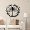Elegant black dragonfly metal wall art hanging on a light-colored wall above a white sofa.