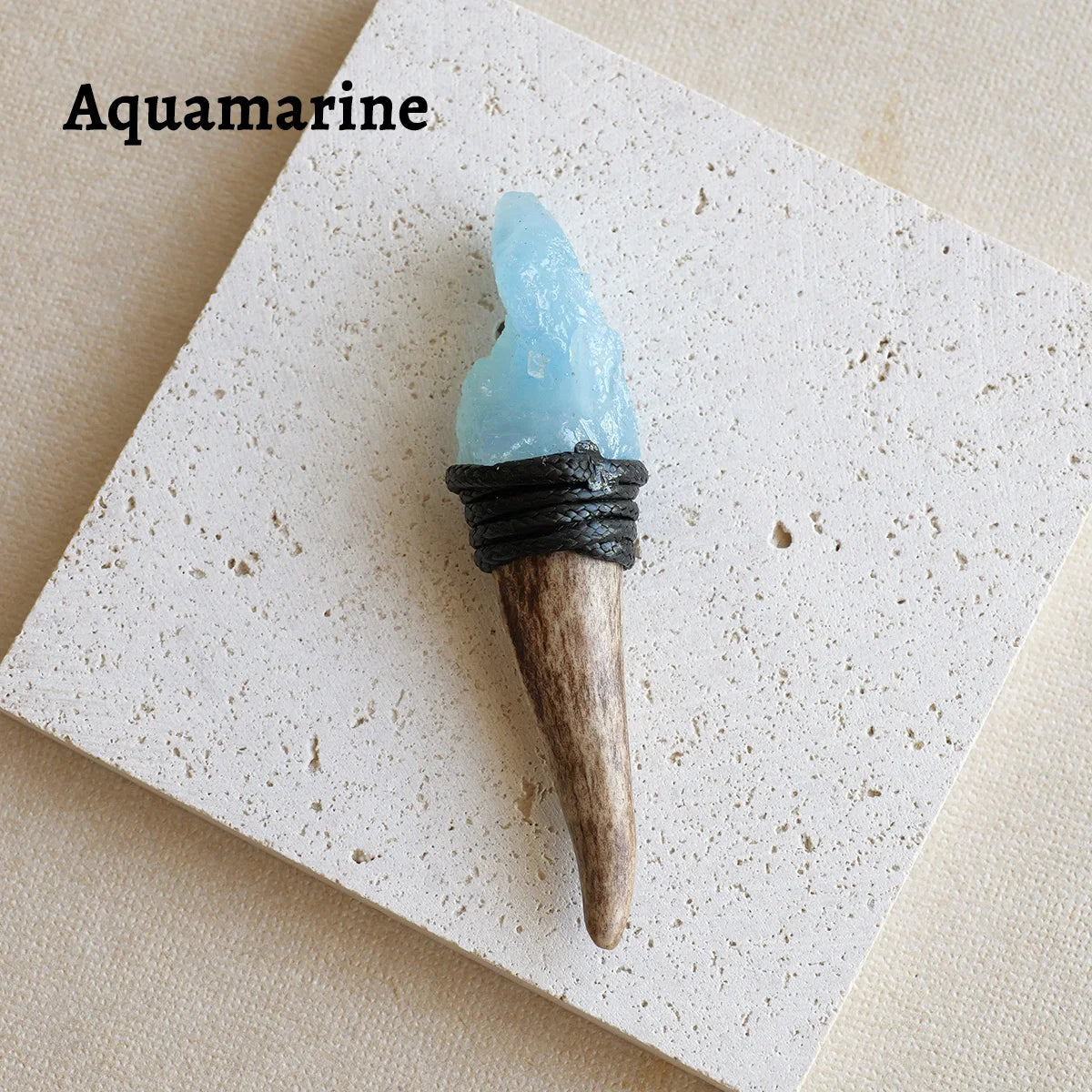 A light blue aquamarine crystal mounted on a wooden scepter wand for spiritual decor.