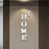 Wall mirror decal featuring the word HOME in silver letters with a butterfly design.