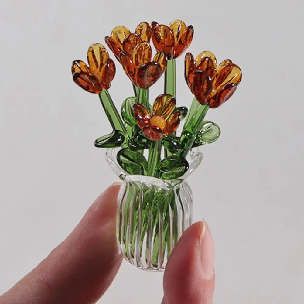 A hand-blown glass flower bouquet featuring orange and yellow tulips in a clear glass vase.