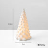 A white ceramic glow-in-the-dark mini Christmas tree decor shaped like a conical evergreen.