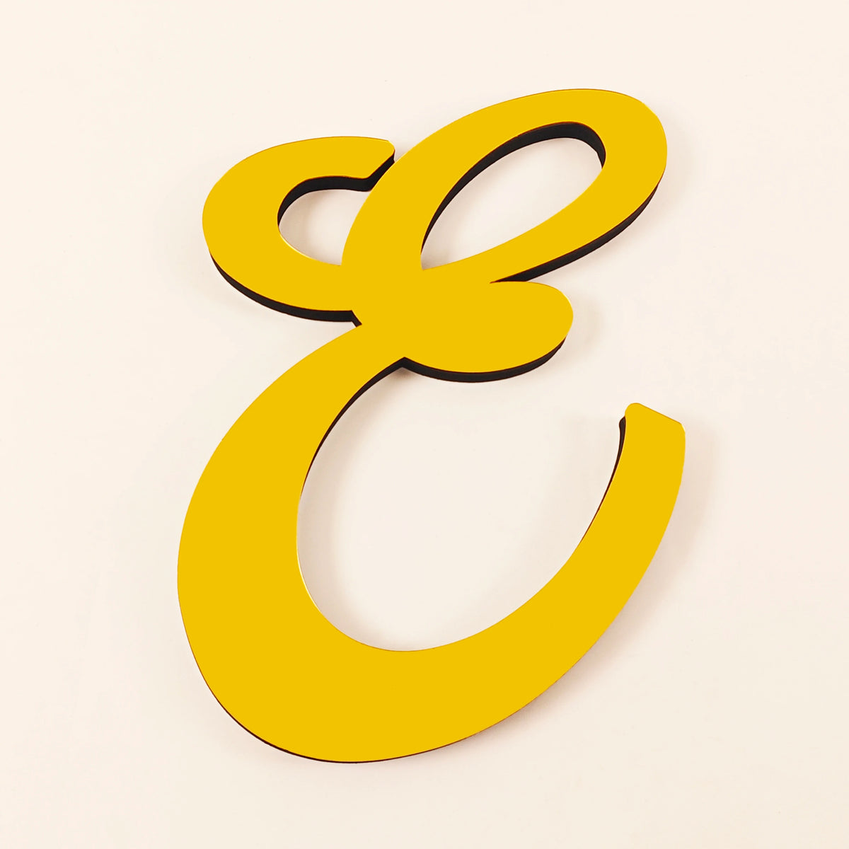 A gold 3D acrylic letter wall sticker shaped like the capital letter E.