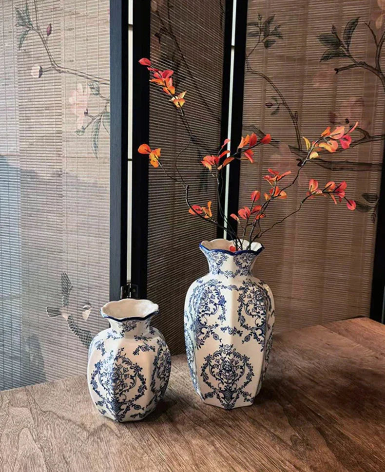 A pair of hand-painted blue and white porcelain vases displayed on a wooden surface against a textured background.