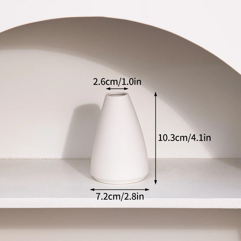 A white ceramic vase is displayed on a shelf, showing its dimensions.