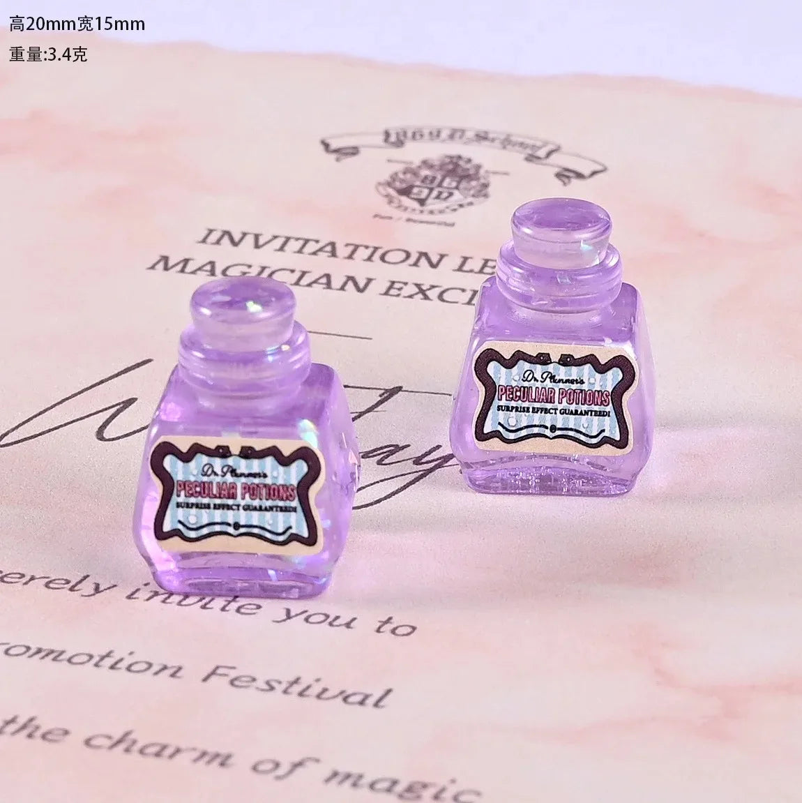 Two small purple resin potion bottles with labels are displayed on a pink paper background.
