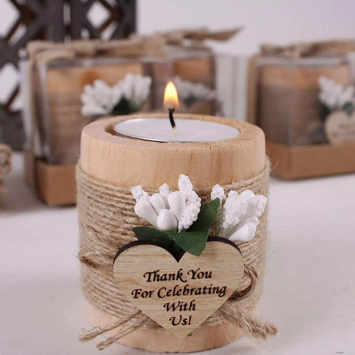 A natural wooden candle holder wrapped in twine features a white flower and a heart-shaped wooden tag that reads Thank You Fo