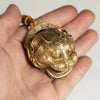 A hand holds a pure copper lucky tiger head bell for Feng Shui decor.