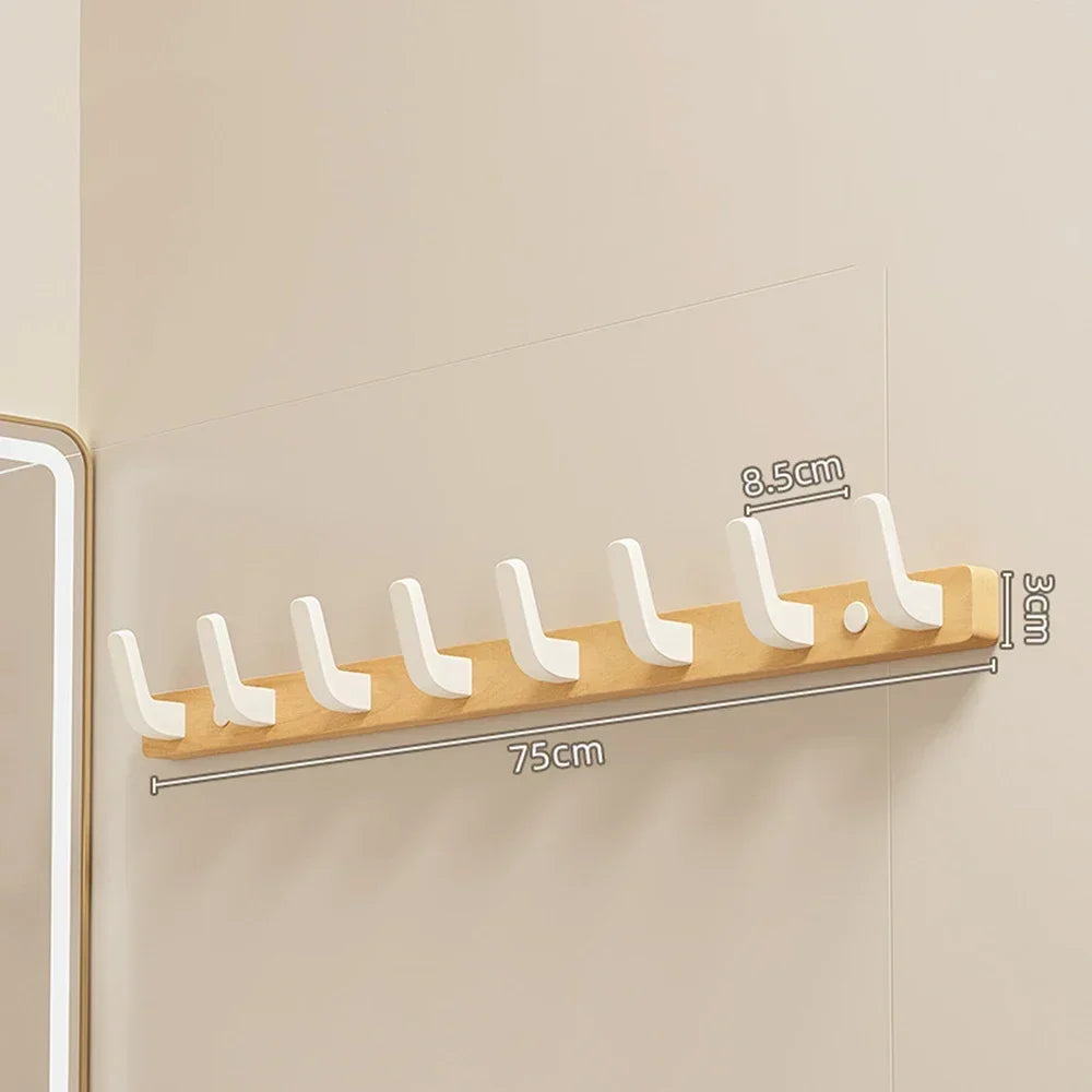 A walnut wood coat rack with eight white hooks and a storage shelf mounted on a light-colored wall.