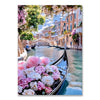 A diamond painting kit featuring a scenic view of European architecture and a pink flower arrangement on a boat.
