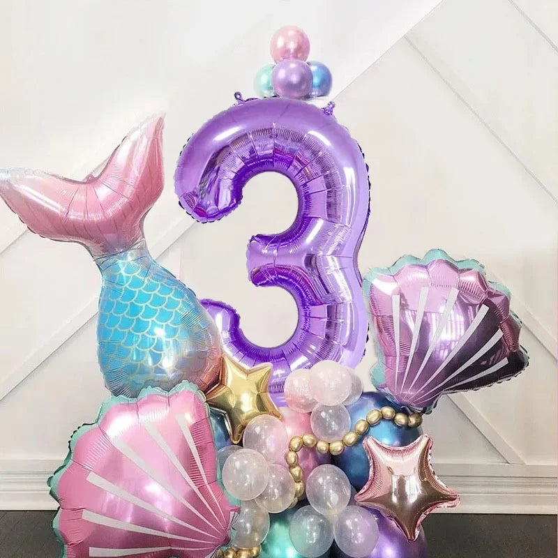 A set of purple and pink mermaid shell number balloons forming the number three for a party decoration