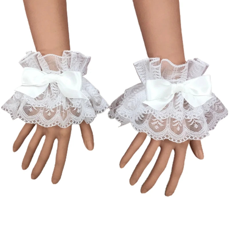 White ruffled lace wrist cuffs with bowknot accents worn on a hand.