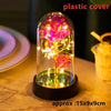 A glass dome containing an LED galaxy rose artificial flower illuminated with bright pink and yellow lights.