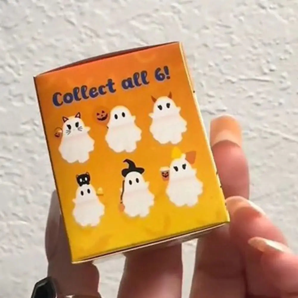 A yellow card with the text Collect all 6 and six white ghost figures on it, held in a hand.
