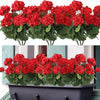 A close-up of vibrant red silk begonia artificial flowers in a green pot.
