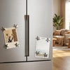A silver refrigerator features vintage star-shaped magnets for photos and notes on the door.