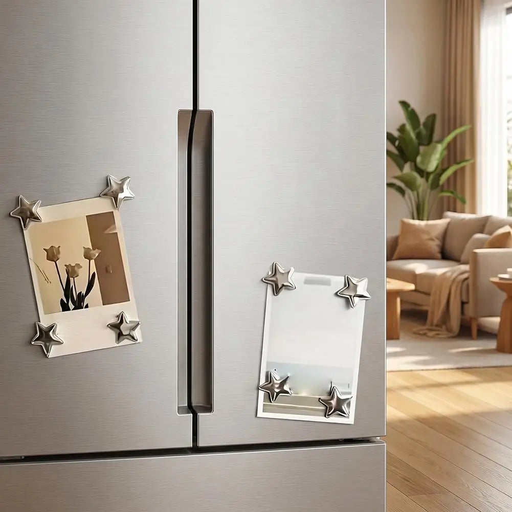 A silver refrigerator features vintage star-shaped magnets for photos and notes on the door.