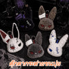 A collection of dark and light gray bunny plush keychains with embroidered features and white stitching.