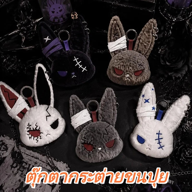 A collection of dark and light gray bunny plush keychains with embroidered features and white stitching.