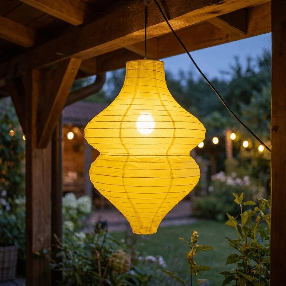 Linterna de flor vintage artesanal amarilla brillante colgando en una pérgola de madera al anochecer.
