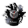 A black wall clock shaped like a vinyl record featuring silhouettes of jazz musicians and a clock face.