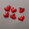 A set of five glossy red heart-shaped fridge magnets arranged on a gray surface.