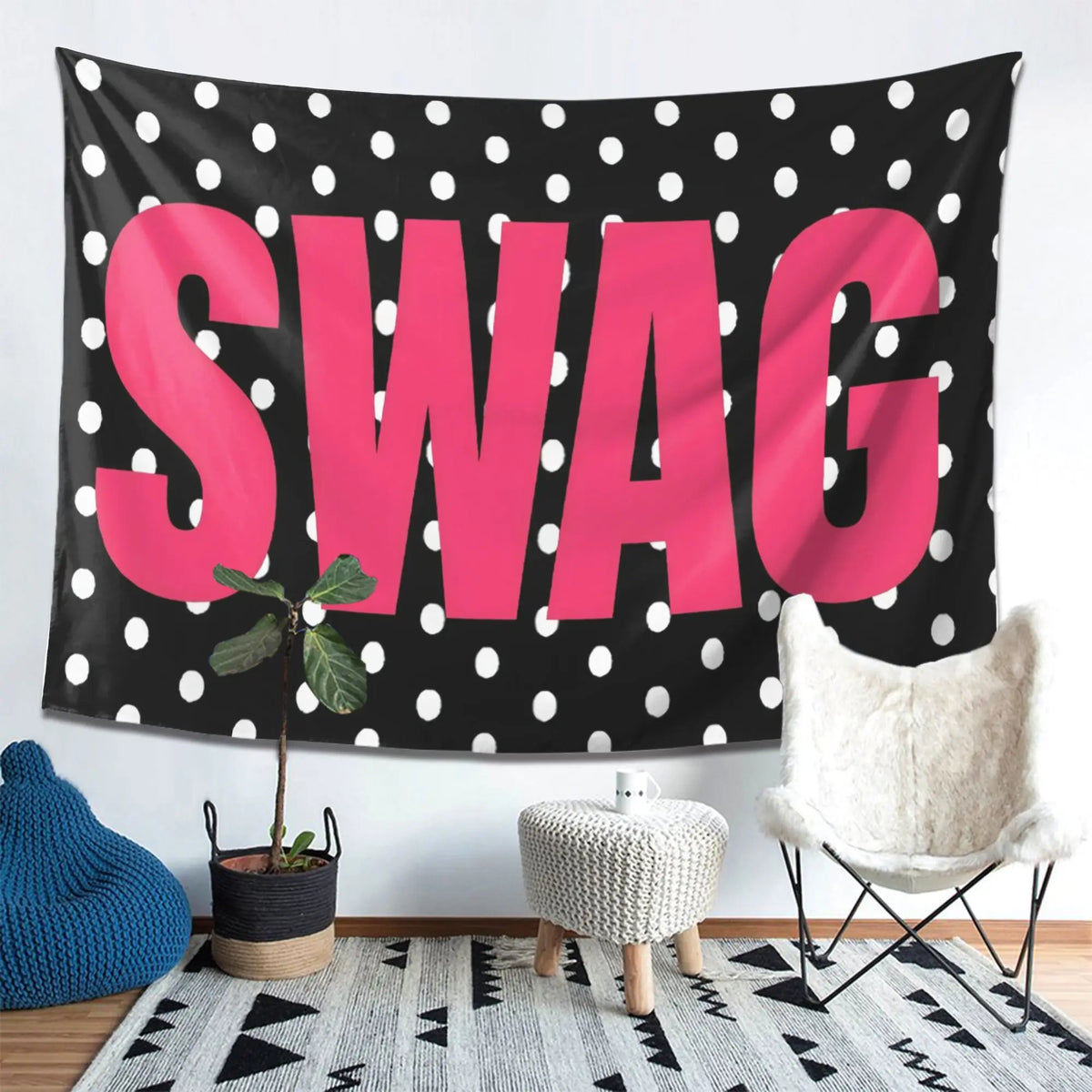 A pink polka dot tapestry featuring the word SWAG hanging on a wall.