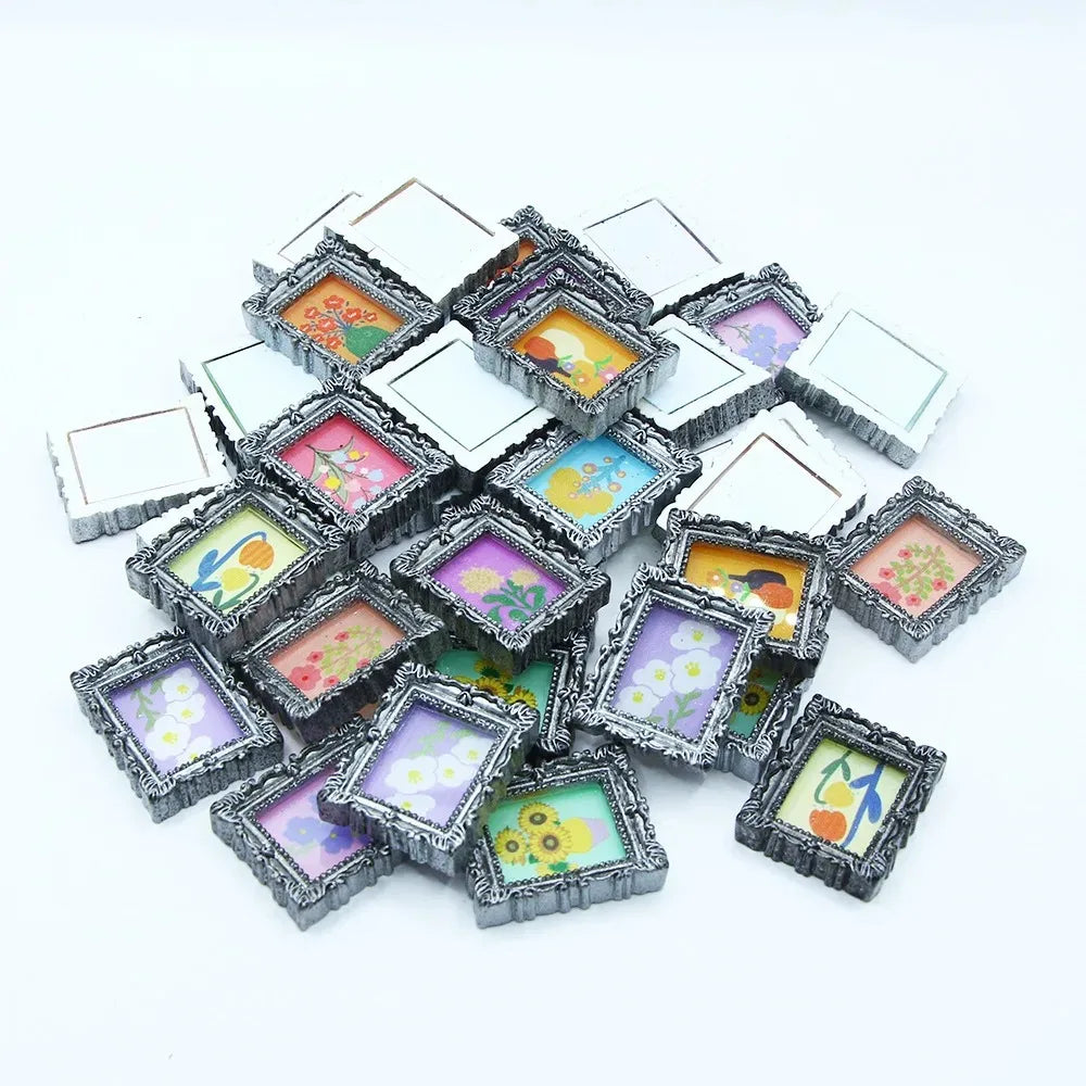 A collection of miniature framed wall art pieces with various floral and nature designs for dollhouse decor