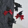 A set of black and red devil horn and bat wing hair clips for Halloween