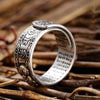 Silver pixiu ring with detailed coin engravings resting on dry branches